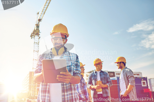 Image of builder in hardhat with tablet pc at construction