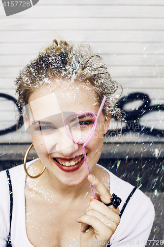 Image of young pretty party girl smiling covered with glitter tinsel, fas