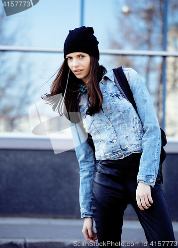 Image of young pretty girl near business building walking