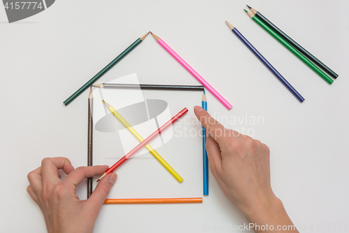 Image of Female hands corrected pencils, making one wooden house