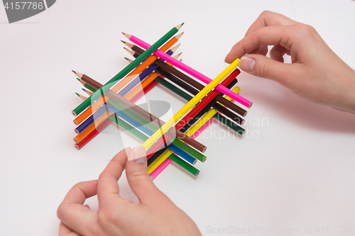 Image of She builds a well of pencils, white background, close-up