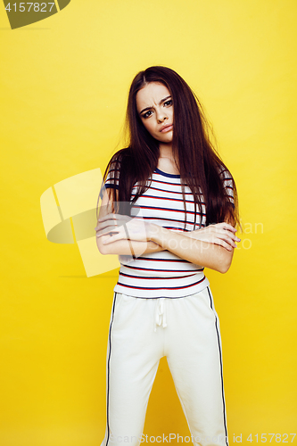 Image of young pretty teenage woman emotional posing on yellow background, fashion lifestyle people concept 
