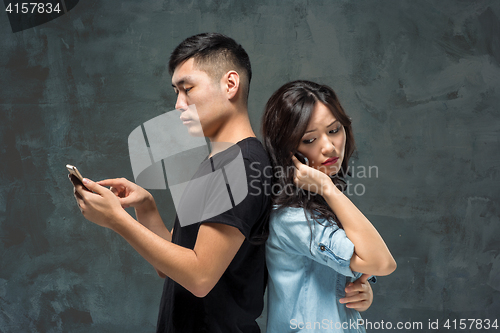 Image of Asian young couple using cellphone, closeup portrait.