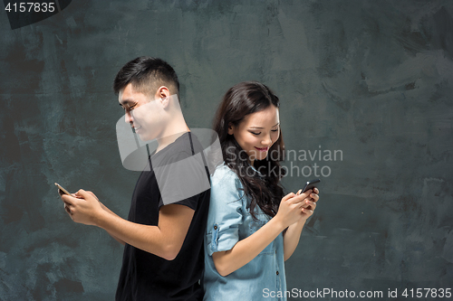 Image of Asian young couple using cellphone, closeup portrait.