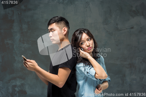 Image of Asian young couple using cellphone, closeup portrait.