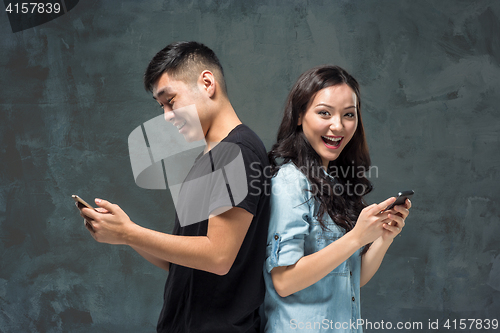 Image of Asian young couple using cellphone, closeup portrait.