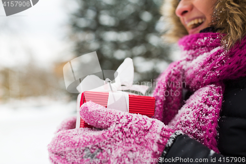Image of close up of woman with christmas gift outdoors