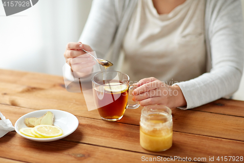 Image of close up of ill woman drinking tea with lemon