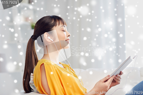 Image of happy asian woman with tablet pc and earphones