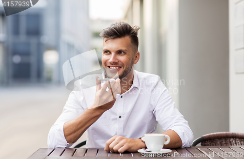 Image of man with coffee and smartphone at city cafe