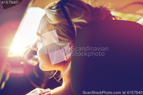 Image of happy teenage girl or young woman in car