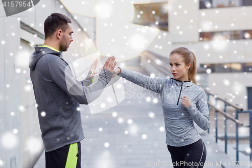 Image of woman with coach working out strike outdoors