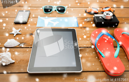 Image of tablet pc, airplane ticket and beach stuff