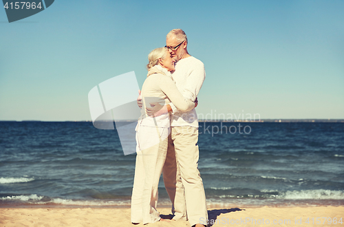 Image of happy senior couple hugging on summer beach