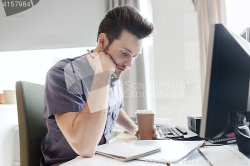 Image of creative male office worker with coffee thinking