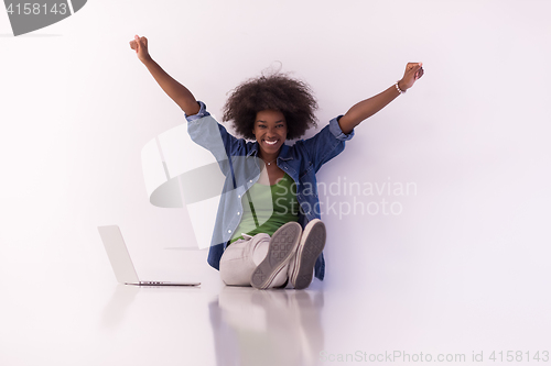 Image of african american woman sitting on floor with laptop