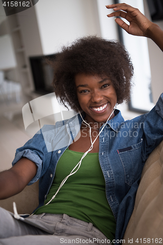 Image of African american woman at home in chair with tablet and head pho