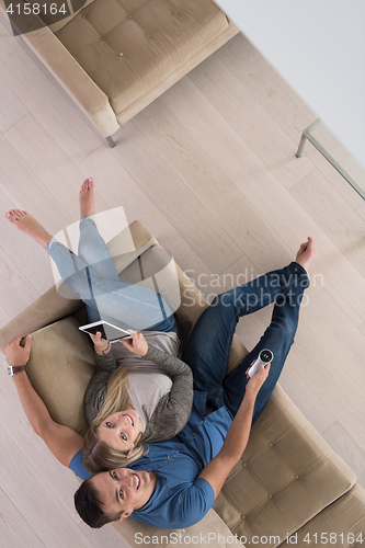 Image of youg couple in living room with tablet top view