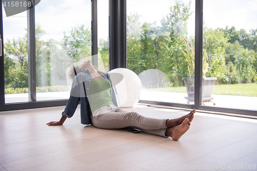 Image of african american  woman  sitting near window