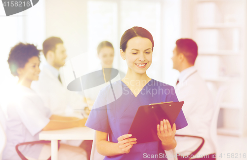 Image of happy doctor over group of medics at hospital