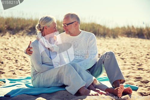 Image of happy senior couple hugging on summer beach