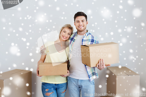 Image of smiling couple with boxes moving to new home