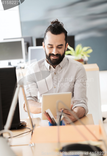 Image of happy creative male office worker with tablet pc