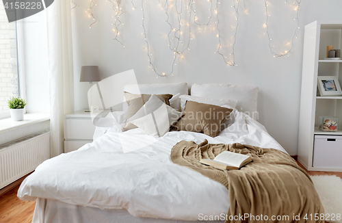 Image of bedroom with bed and christmas garland at home