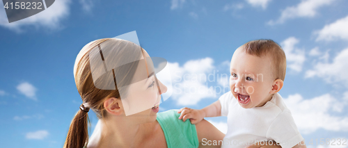 Image of happy young mother with little baby over blue sky