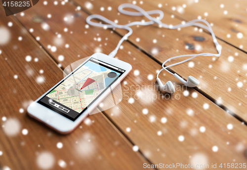 Image of close up of smartphone and earphones on wood