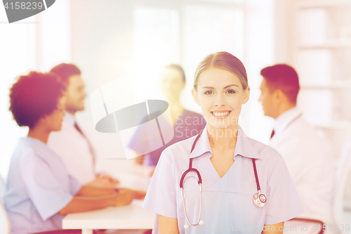 Image of happy doctor over group of medics at hospital