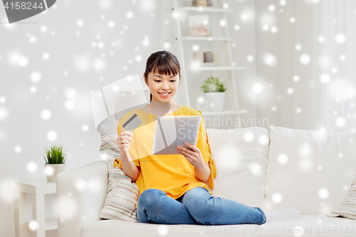 Image of happy asian woman with tablet pc and credit card