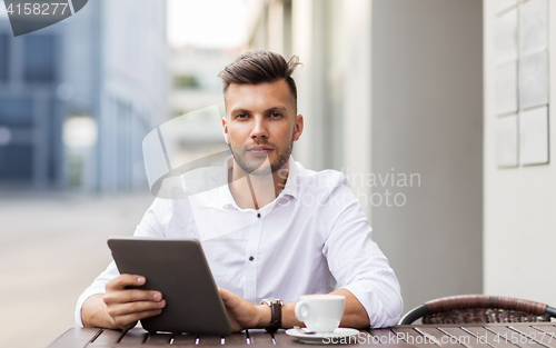 Image of man with tablet pc and coffee at city cafe