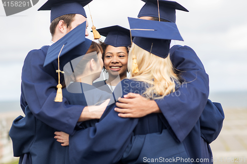 Image of happy students or bachelors hugging