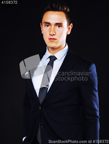 Image of young pretty business man standing on black background, modern h