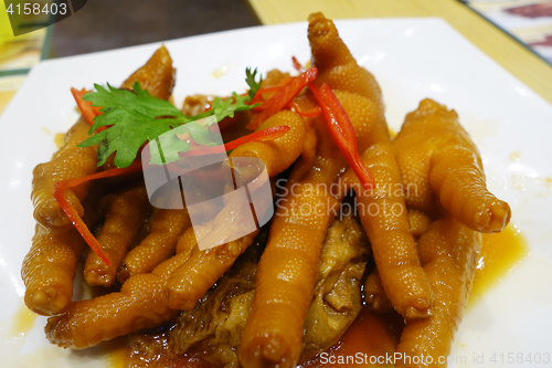 Image of Cooked chicken feet in a white plate