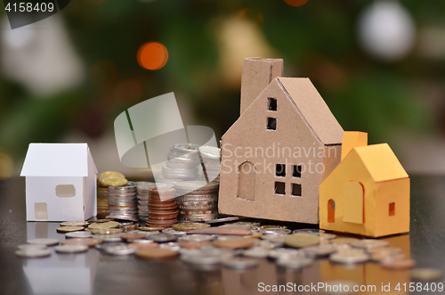 Image of Paper house and stacks of coins standing