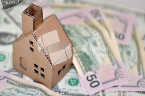 Image of Miniature paper made house stand on  money