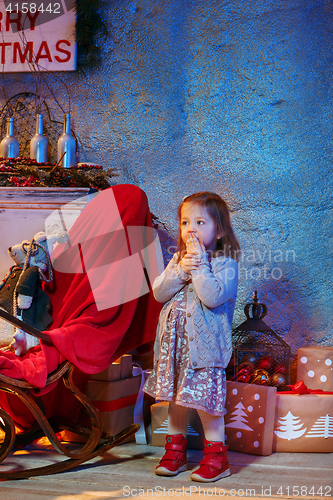 Image of Little girl and rocking chair near fireplace