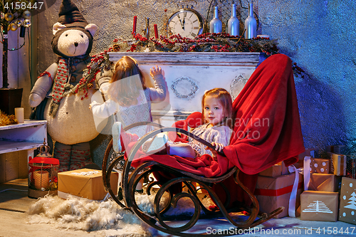 Image of Little girl and rocking chair near fireplace