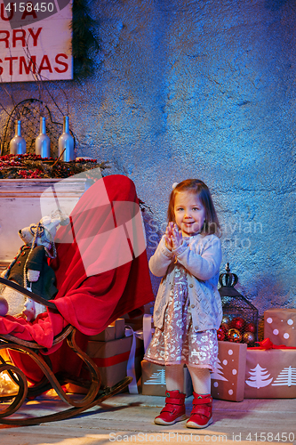 Image of Little girl and rocking chair near fireplace