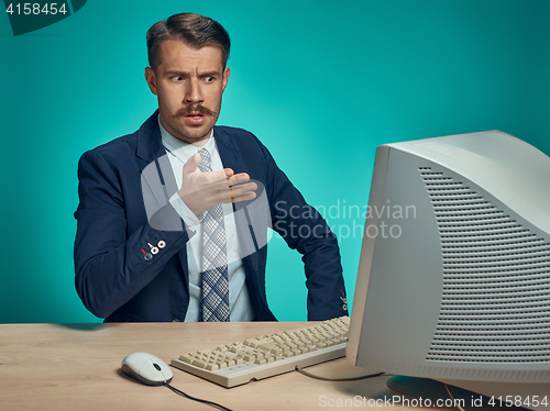 Image of Sad Young Man Working On computer At Desk