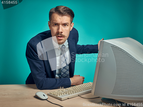 Image of Sad Young Man Working On computer At Desk