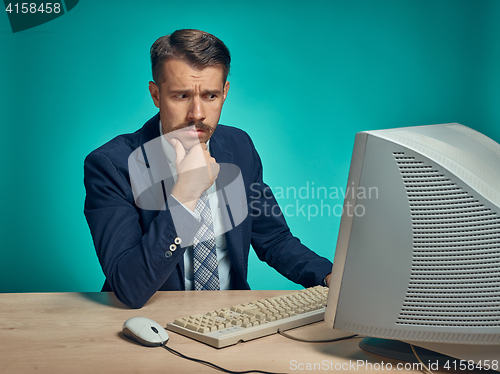 Image of Sad Young Man Working On computer At Desk