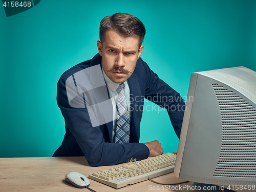 Image of Sad Young Man Working On computer At Desk