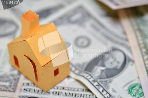 Image of Miniature paper made house stand on  money