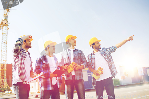 Image of group of smiling builders with tablet pc outdoors