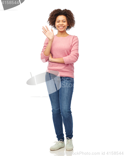 Image of happy african american young woman waving hand