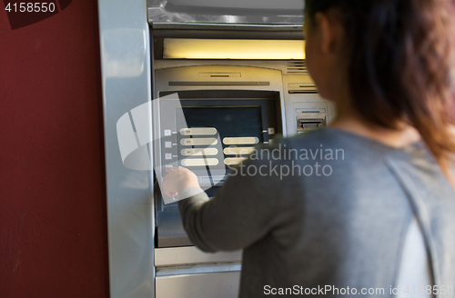 Image of close up of woman choosing option on atm machine