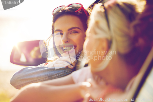 Image of happy teenage girls or women in car at seaside